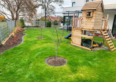 Garten mit Bäumchen und Spielplatz
