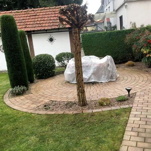 terrasse runde gepflasterte Steinterasse im Garten mit Bäumchen und Sträuchern