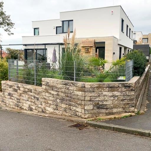 trockenmauer Mauer aus hellen Steinen als Begrenzung zum garten